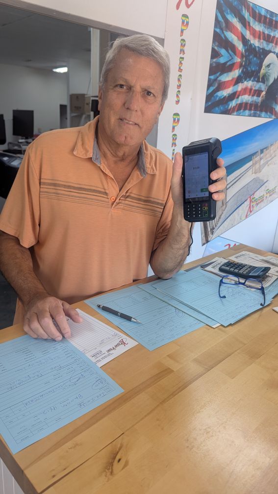 Harold Motter holding his PayWavez terminal at Xpress Print